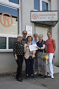 Spendenübergabe an Tafel Lüdenscheid vor dem Gebäude der Tafel mit Spendenscheck über 1500 €